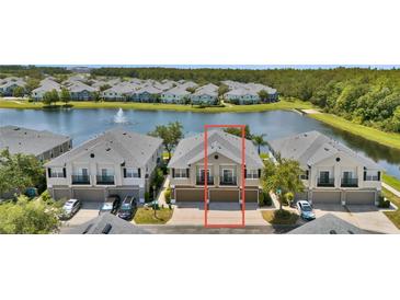 Beautiful townhome featuring two-car garage with lush landscaping and tranquil lake view at 6462 S Goldenrod Rd # 31B, Orlando, FL 32822