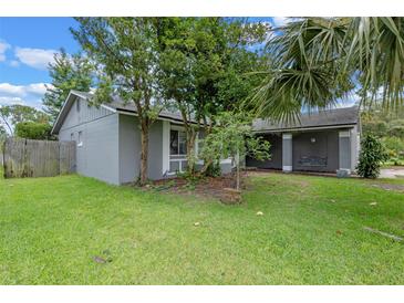 Side view of a grey home with a well manicured lawn and covered porch at 885 Little Bend Rd, Altamonte Springs, FL 32714