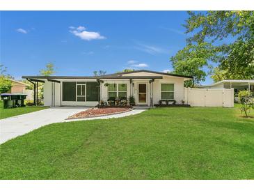Charming single-story home with a green lawn, modern exterior, and curved walkway to the front door at 1208 Baltimore Dr, Orlando, FL 32810