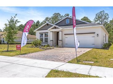 Well-manicured front yard with a brick paver driveway leading to a charming single-Gathering home at 1249 Champions Dr, Daytona Beach, FL 32124