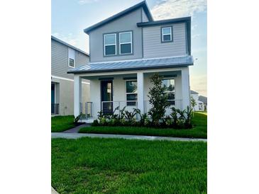 Charming two-story home featuring a well-manicured lawn and a welcoming front porch at 16454 Silver Brook Way, Winter Garden, FL 34787