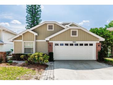 Charming single-story home features a two-car garage, brick accents, and well-maintained landscaping at 3065 Bridgehampton Ln, Orlando, FL 32812