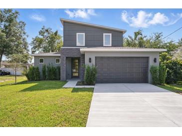 Modern two-story home with dark gray stucco, stone accents, manicured lawn, and large driveway at 3650 Grant Blvd, Orlando, FL 32804