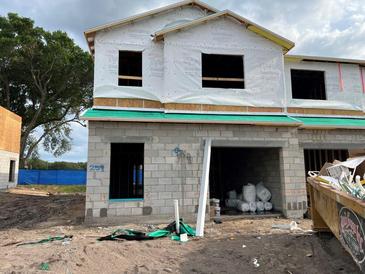 Unfinished exterior of a two-story townhome, showing the initial construction phase with exposed materials at 4244 Campsite Loop, Orlando, FL 32824