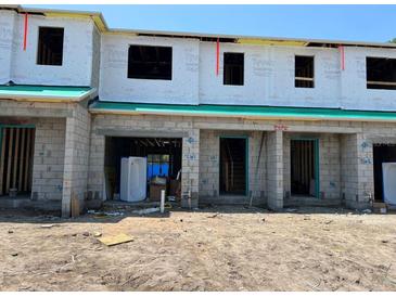 Unfinished townhouse exteriors showing the beginning stages of construction with open window and door frames at 4252 Campsite Loop, Orlando, FL 32824