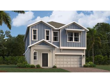 Charming two-story home featuring stylish blue siding, white trim, and an attached two car garage at 640 Terrapin Dr, Debary, FL 32713