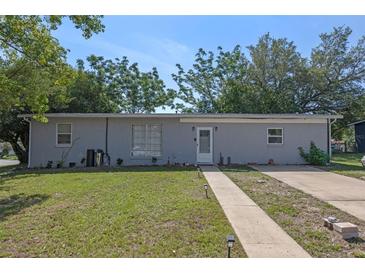 Charming single-story home featuring a well-maintained lawn and a classic brick facade at 985 N Village Dr, Deltona, FL 32725