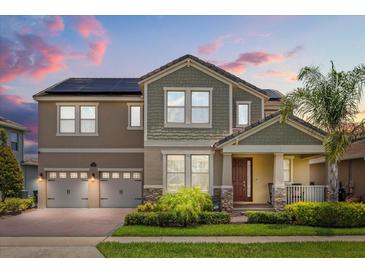 Stunning two-story home featuring a well-manicured lawn, a two-car garage, and solar panels for energy efficiency at 9873 Lost Creek Dr, Winter Garden, FL 34787