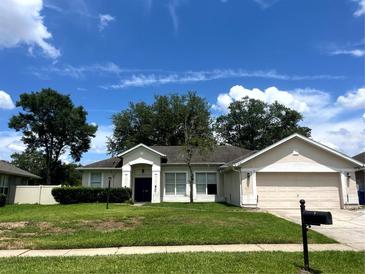 Charming single-story home with a well-manicured lawn and attached two-car garage at 1131 Turtle Lake Ct, Ocoee, FL 34761