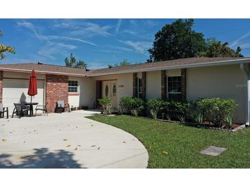 Charming single-story home with brick accents, landscaped yard, and inviting outdoor seating area at 1135 Plato Ave, Orlando, FL 32809
