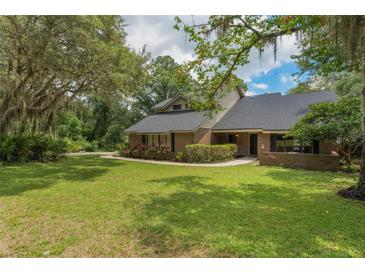 Charming two-story home features a lush lawn, mature trees and inviting walkway, creating a welcoming curb appeal at 120 E Greentree Ln, Lake Mary, FL 32746