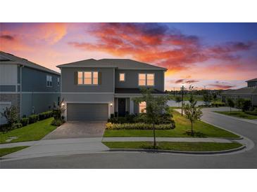 Charming two-story home featuring manicured lawn, tasteful landscaping, and a two car garage at 13822 Destin Beach Ln, Orlando, FL 32827