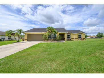 Charming one-story home with lush green lawn, mature landscaping, and a paved driveway at 3600 Fountainbleu Blvd, Kissimmee, FL 34746