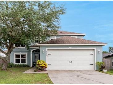 Charming two-story home featuring a two-car garage, well-maintained lawn, and mature trees at 4756 Fiske Cir, Orlando, FL 32826