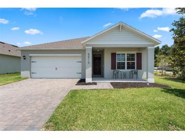 Charming single-story home featuring a two-car garage, manicured lawn and a cozy front porch at 5515 Palomino Pl, Apopka, FL 32712