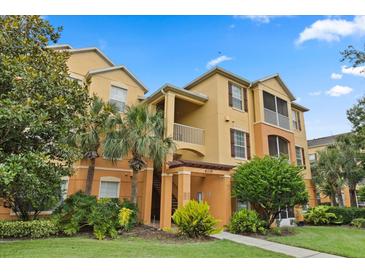 Attractive condo building showcasing well-maintained landscaping and classic architectural details under a blue sky at 6335 Contessa Dr # 208, Orlando, FL 32829