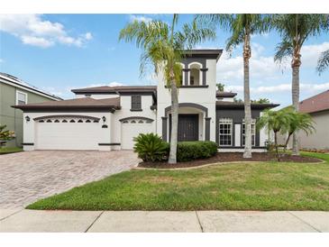 Beautiful two story home with 3 car garage and landscaped front yard with palm trees at 1429 Arbitus Cir, Oviedo, FL 32765