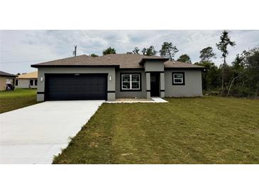 Beautiful single-story home featuring gray stucco, black trim, and a well-manicured lawn at 14990 Sw 29Th Ave Rd, Ocala, FL 34473