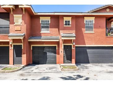 Charming townhome featuring colorful stucco facade, attached garages, and convenient front door access at 173 Villa Di Este Ter # 209, Lake Mary, FL 32746