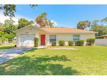 Charming single-story home with well-maintained lawn, red door, and attached garage at 620 Unabelle Ave, Holly Hill, FL 32117