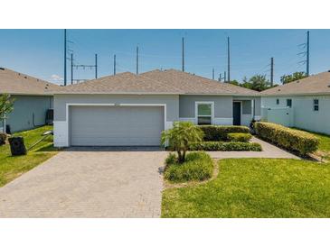 Charming single-story home with a well-manicured lawn and a two car garage at 14357 Hidden Ct, Clermont, FL 34711
