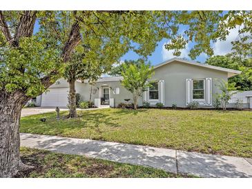 Charming single-story home boasts a well-manicured lawn, beautiful landscaping, and a welcoming front entrance at 2312 Poinciana Rd, Winter Park, FL 32792