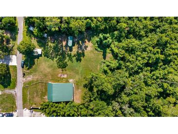 Aerial view of a lush property with a green roofed building, green space, and trees at 287 Hilltop Dr, Longwood, FL 32750