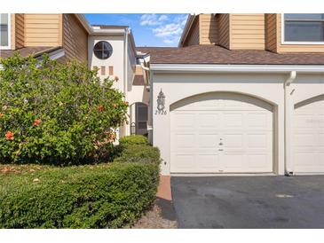 Charming townhome featuring a garage, arched entryway, and well-maintained landscaping at 2926 Claremont Ct # Ge, Orlando, FL 32822