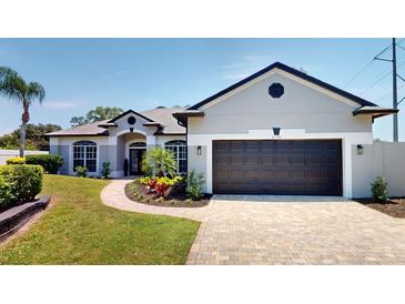 Charming single-story home featuring a well-manicured lawn, beautiful landscaping, and a two-car garage at 6198 Linneal Beach Dr, Apopka, FL 32703