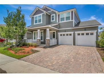 Beautiful two-story home with a three car garage, manicured lawn and brick paver driveway at 8230 Corkfield Ave, Orlando, FL 32832