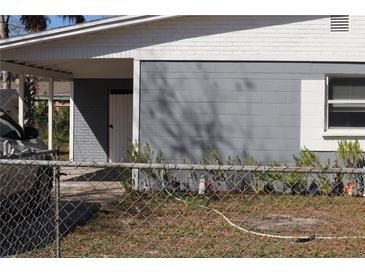 A exterior shot of a grey and white home, car parked beneath the carport at 1212 Leon Ln, Daytona Beach, FL 32117