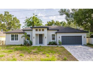 Beautifully renovated single-story home with a gray exterior, freshly landscaped yard, and a two-car garage at 1331 19Th St, Orlando, FL 32805