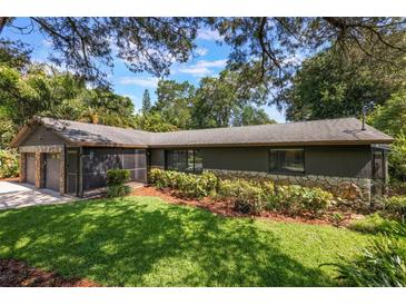 Exterior of a home with lush greenery, a well-maintained lawn, and a stone and siding facade at 1343 Charlotte St, Altamonte Springs, FL 32701
