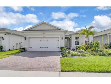 Charming single-story home featuring a brick driveway, two-car garage, and a lush landscaped yard at 1425 Lone Wood Blvd, Orlando, FL 32828