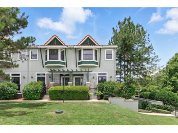 Charming townhome with a landscaped front yard and lush greenery, offering curb appeal and a welcoming entrance at 14501 Damai Ln, Orlando, FL 32821