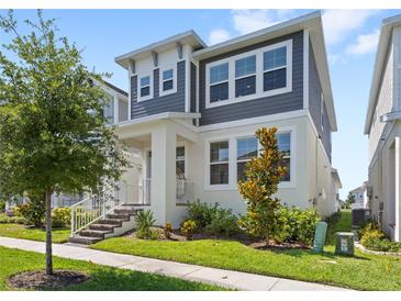 Charming two-story home with gray and white exterior, lush landscaping, and inviting front porch at 15444 Lebeau Loop, Winter Garden, FL 34787