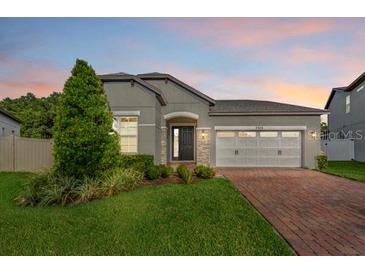 Charming single-story home featuring a well-manicured lawn, a two-car garage, and beautiful landscaping at 2914 Scarlett Dr, St Cloud, FL 34772