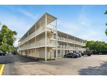 Condo building with three stories, exterior staircases, parking, and white facade at 320 Lakeview St # 220, Orlando, FL 32804