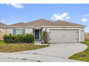Charming single-story home featuring a two-car garage, landscaped yard, and neutral-toned facade at 3405 Yarian Dr, Haines City, FL 33844