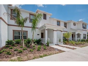 Charming townhome exterior with lush landscaping and a welcoming covered front porch at 4834 Lullaby Ln, Kissimmee, FL 34746