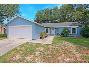 Charming one-story home with blue exterior, well-maintained landscaping, and a two car garage at 5032 Timber Ridge Trl, Ocoee, FL 34761