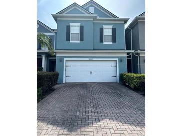 Charming two-story home with a brick driveway and a two-car garage in a well-maintained community at 6024 Chapledale Dr, Orlando, FL 32829