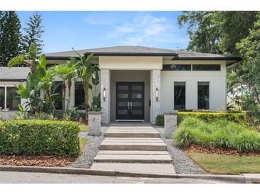 Contemporary home featuring a stylish walkway and modern front door framed by lush landscaping at 7 Ne Ivanhoe Blvd, Orlando, FL 32804