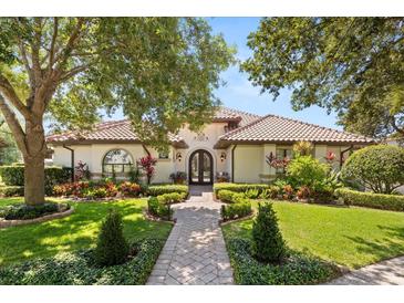 Charming home featuring a well manicured front yard, beautiful landscaping and a classic tile roof at 1010 Juliette Blvd, Mount Dora, FL 32757