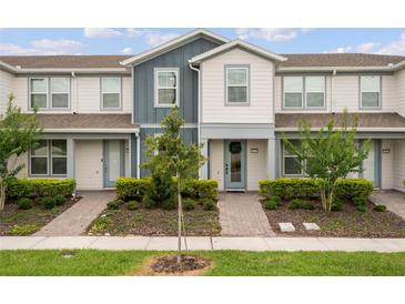 Charming two-story townhouse with a well-manicured lawn and inviting walkway leading to the front door at 14390 Orchid Island Dr, Orlando, FL 32827