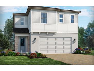 Two-story home featuring a two-car garage, stone-clad entry, and tidy landscaping at 1860 Archer Dr, Minneola, FL 34715