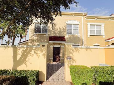 Charming townhome with tan exterior, red tile accents, walkway, and lush landscaping offering a cozy and inviting curb appeal at 2520 Bella Vista Dr, Davenport, FL 33897