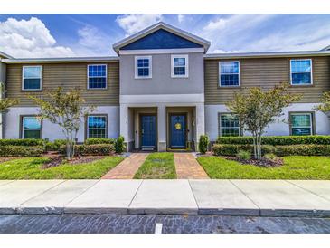 Attractive townhome exterior featuring a landscaped yard and inviting entryway at 322 Annabelle Way, Davenport, FL 33837