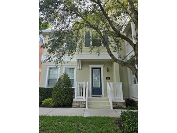 Charming two-story home featuring a blue front door, well-manicured landscaping, and a welcoming front porch at 338 Roberts Family Ln, Winter Springs, FL 32708