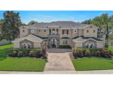 Elegant two-story home with stone accents, arched windows, and manicured landscaping at 3656 Heirloom Rose Pl, Oviedo, FL 32766